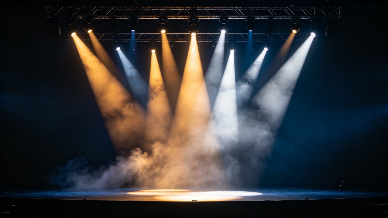 Multiple moving head beams cutting through haze on a theatre stage